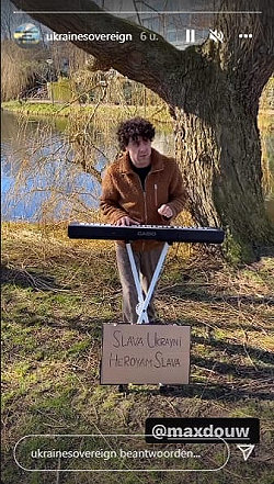 Max Douw speelt in een park met bord Slava Ukrayni Herovam Slava