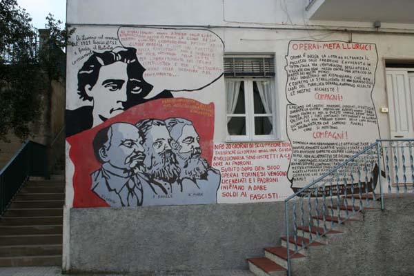 muurschildering van de grote drie onder het wakend oog van Antonio Gramsci