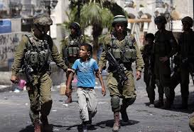 Foto van Israelische militairen die jonge jongen meenemen