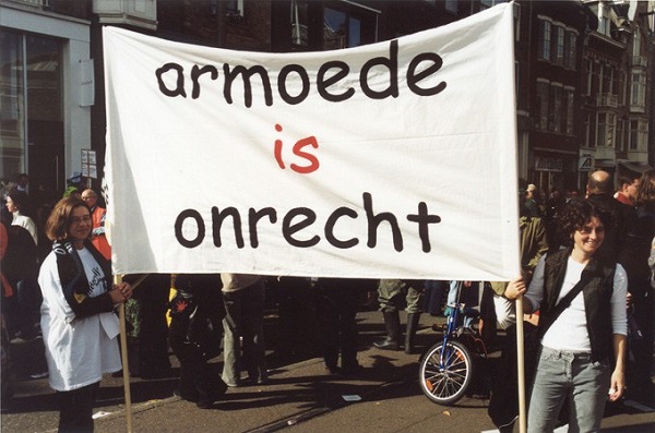 Foto van twee mensen met spandoek Armoede is Onrecht