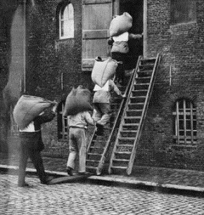 Foto van sjouwers die pakhuis ingaan