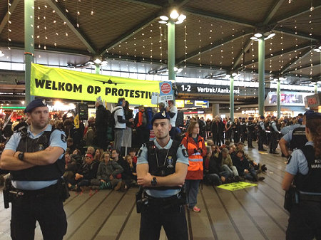 Demo in hal Schiphol met marechausse