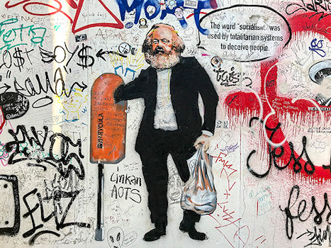 Grafitty muur met Marx als dakloze, hand in afvalcontainer.
