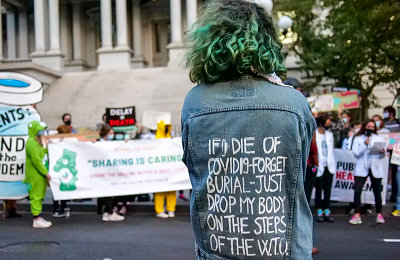 Vrouw met spijkerjack op demo: If I die of COVID19 forget burial - drop my body on the steps of WTO