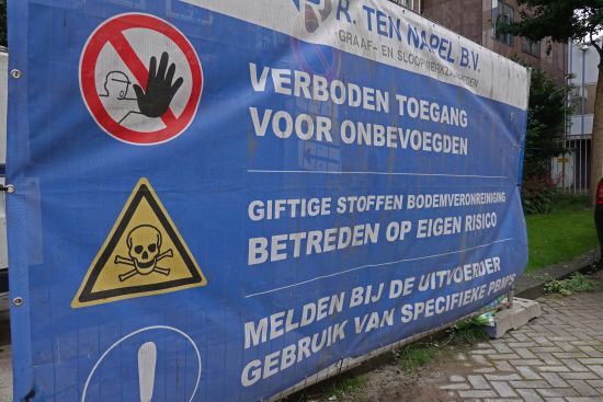 Waarschuwingsspandoek: Verboden toegang - Giftige stoffen bodemverontreiniging, betreden op eigen risico - Melden bij uitvoerder, gebruik van specifieke PBM's