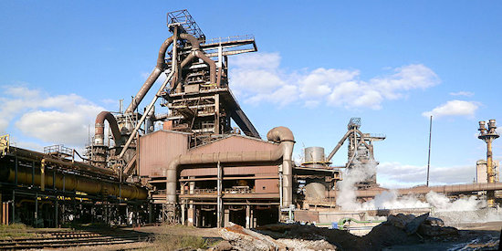 Panorame foto roestbruine hoogoven en fabrieks bebouwn met blauwe lucht