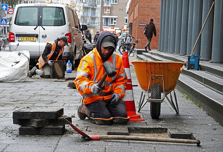 Tegelzetters aan het werk op de stoep