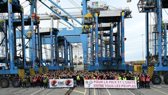 Foto Havenkranen met protesterende werkers EDC en spandoek Lour la Paix et l'Unite entre tous Peuples