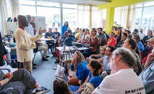 Foto workshop - spreker en tientallen aandacgrige toehoorders